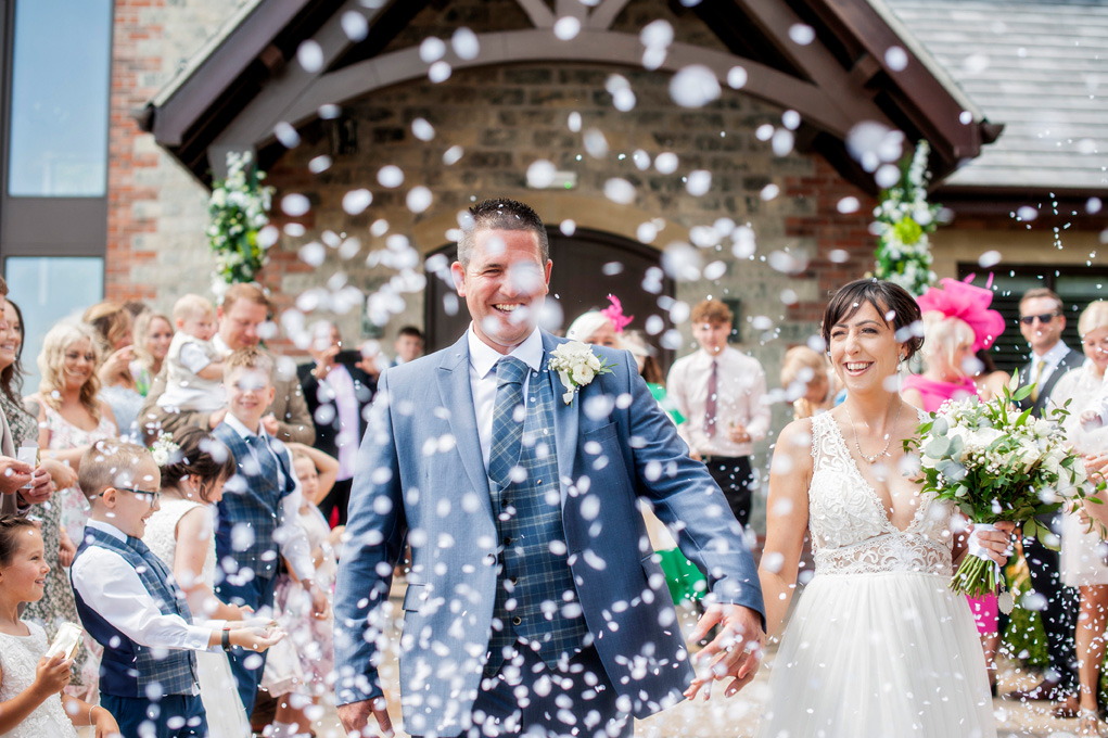 Bride and Groom walking through confetti